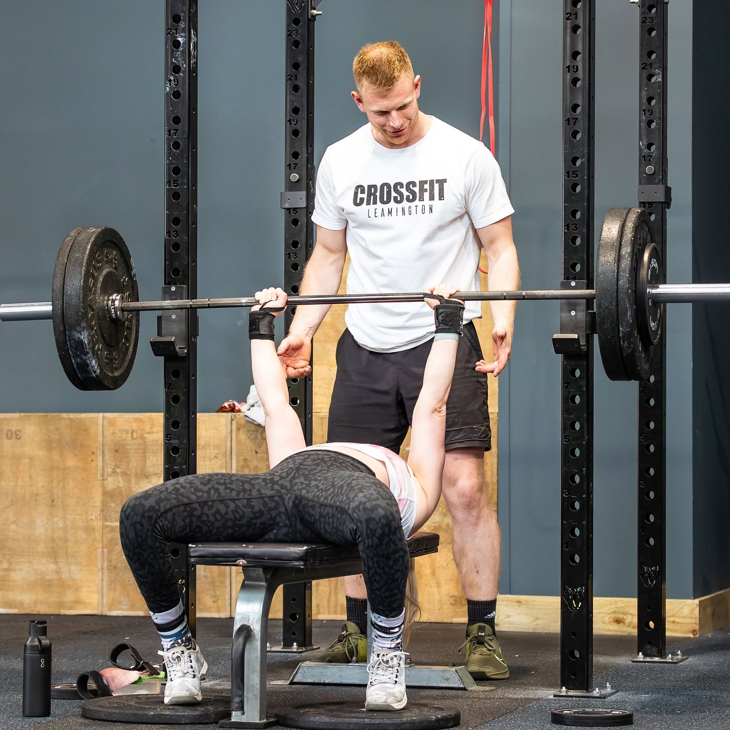 A coach spotting a member's bench press